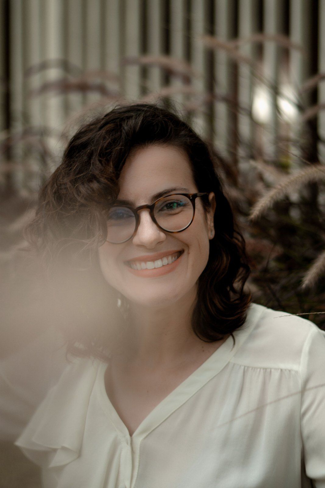 Renata sorrindo entre o capim
